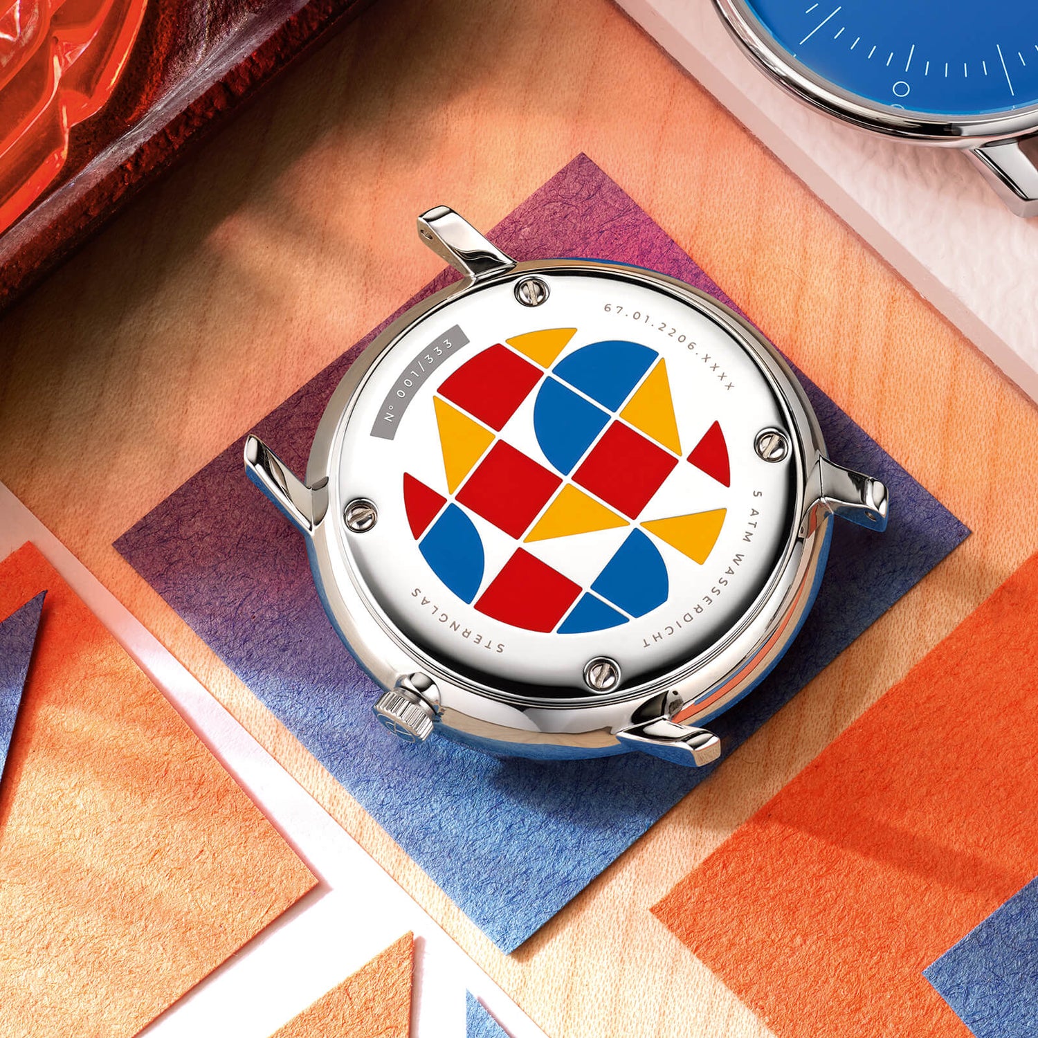 popup|Artful case back with palpable enamel engraving|The screwed case back of this special edition speaks for itself. Primary colors made of enamel, cast in an elaborate and precise form. In addition, the limited edition number makes each piece unique.